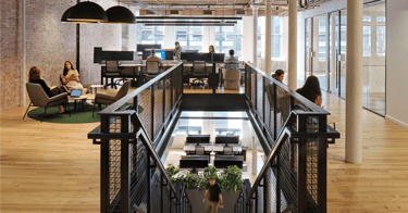 Corporate interiors with people collaborating and interconnecting stair. 